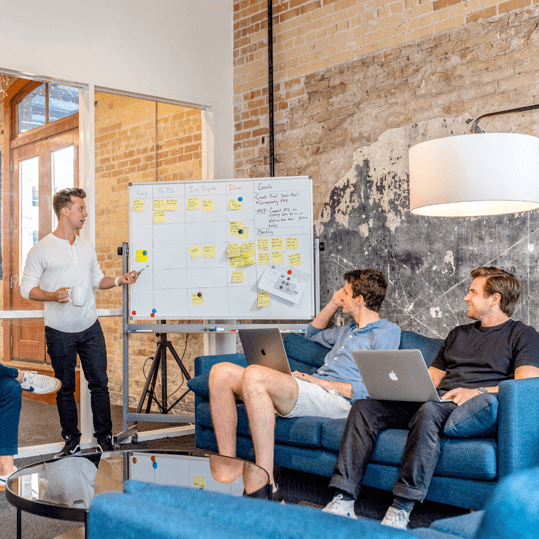 The RDU Digital team planning a project around a whiteboard